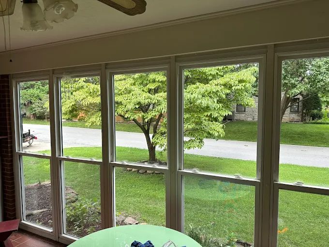 Clean sunroom windows looking out onto a lawn after professional window cleaning