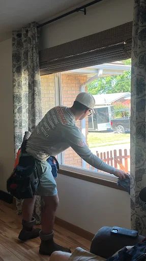 Worker hand-cleaning the inside of a window