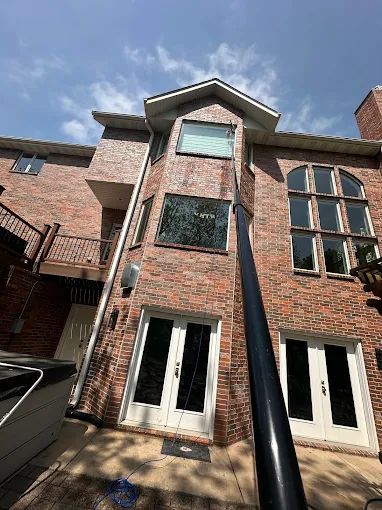 Water-fed pole reaching the upper windows of a tall brick home in Springfield Missouri